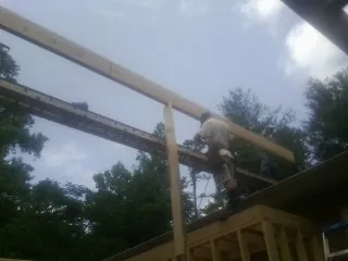 Carpenter setting a ridge beam over a new addition frame — Ice Dam Removal by Roofing Brothers in Bala Cynwyd