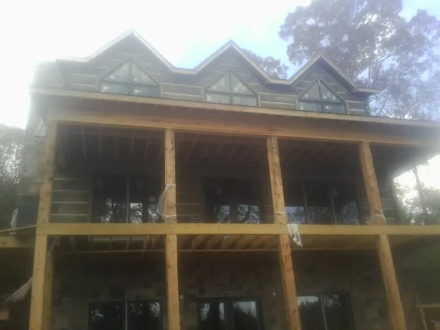 Dormers and porch framing on a large log home under construction — Roof Coating work by our crew in Bala Cynwyd