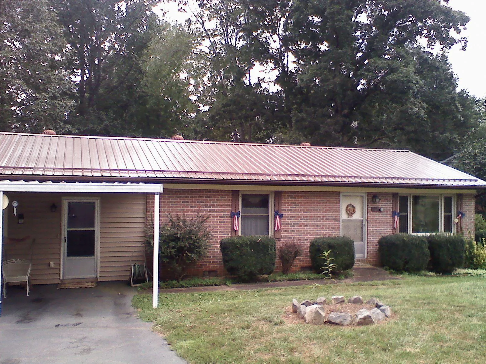 Bronze metal roof and carport on a brick ranch home — Roof Repair work by our crew in Bala Cynwyd